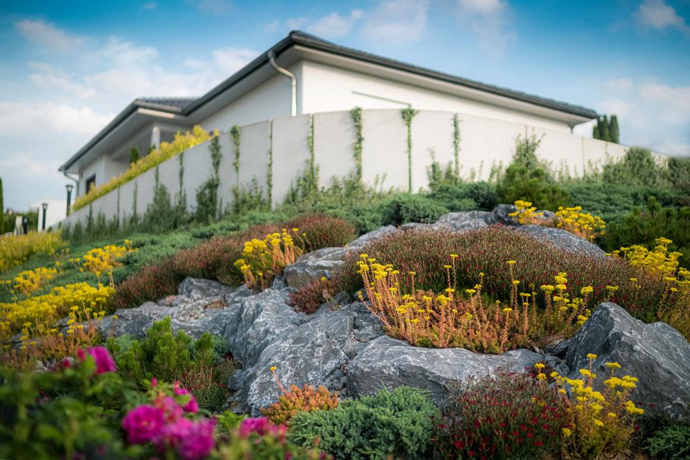Gartenkunst im Vordergrund: Weißes Herrenhaus im Hintergrund eines Naturgartens